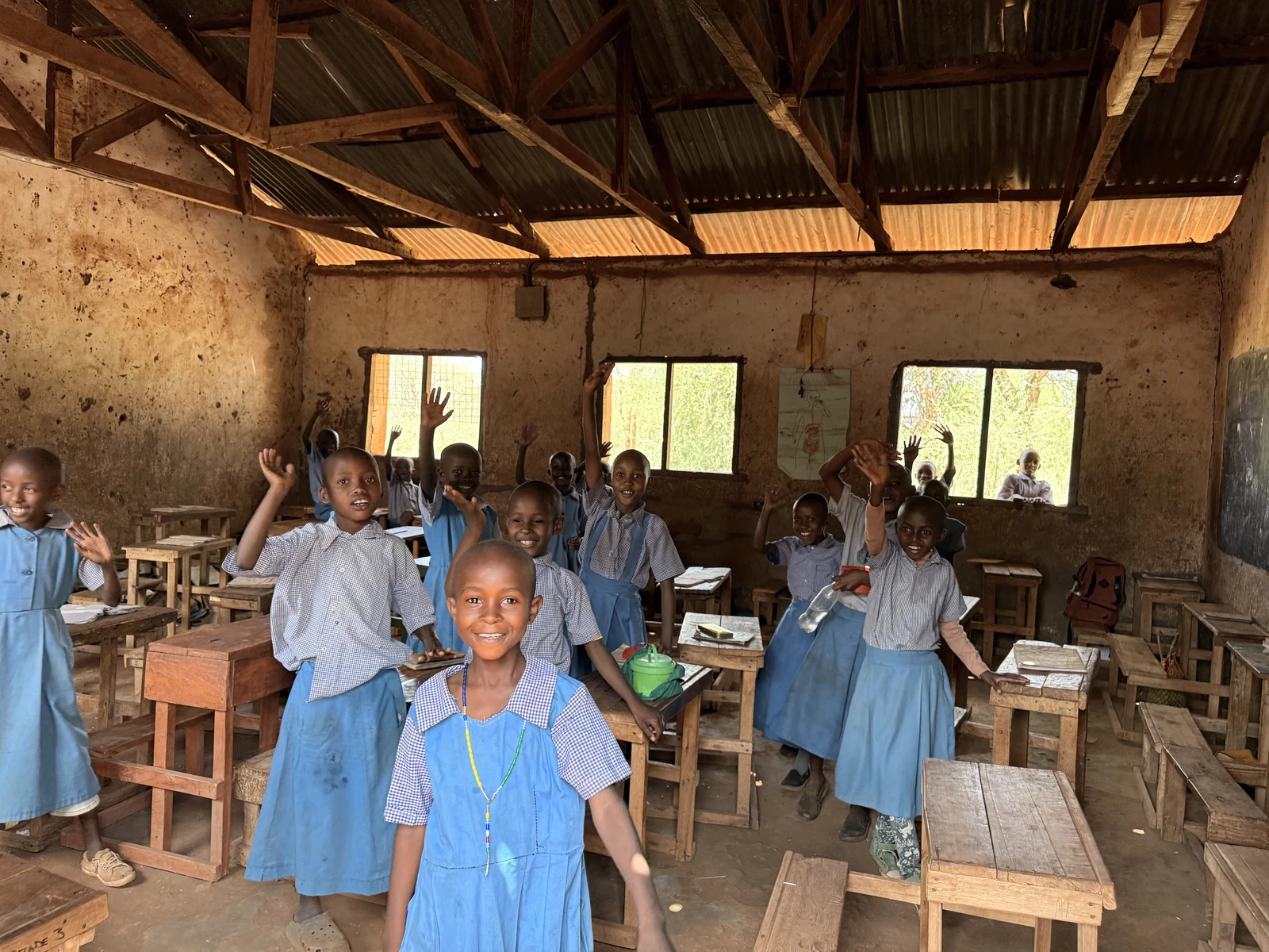 The classroom before repair — mud walls, open roof, no ceiling